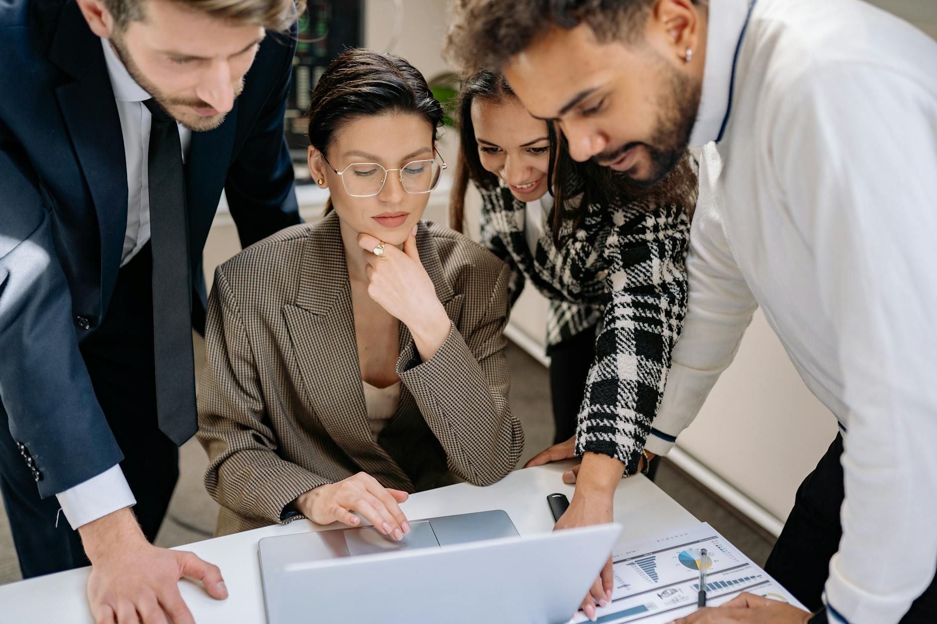 Zespół biurowy omawia strategię wdrożenia AI przy laptopie