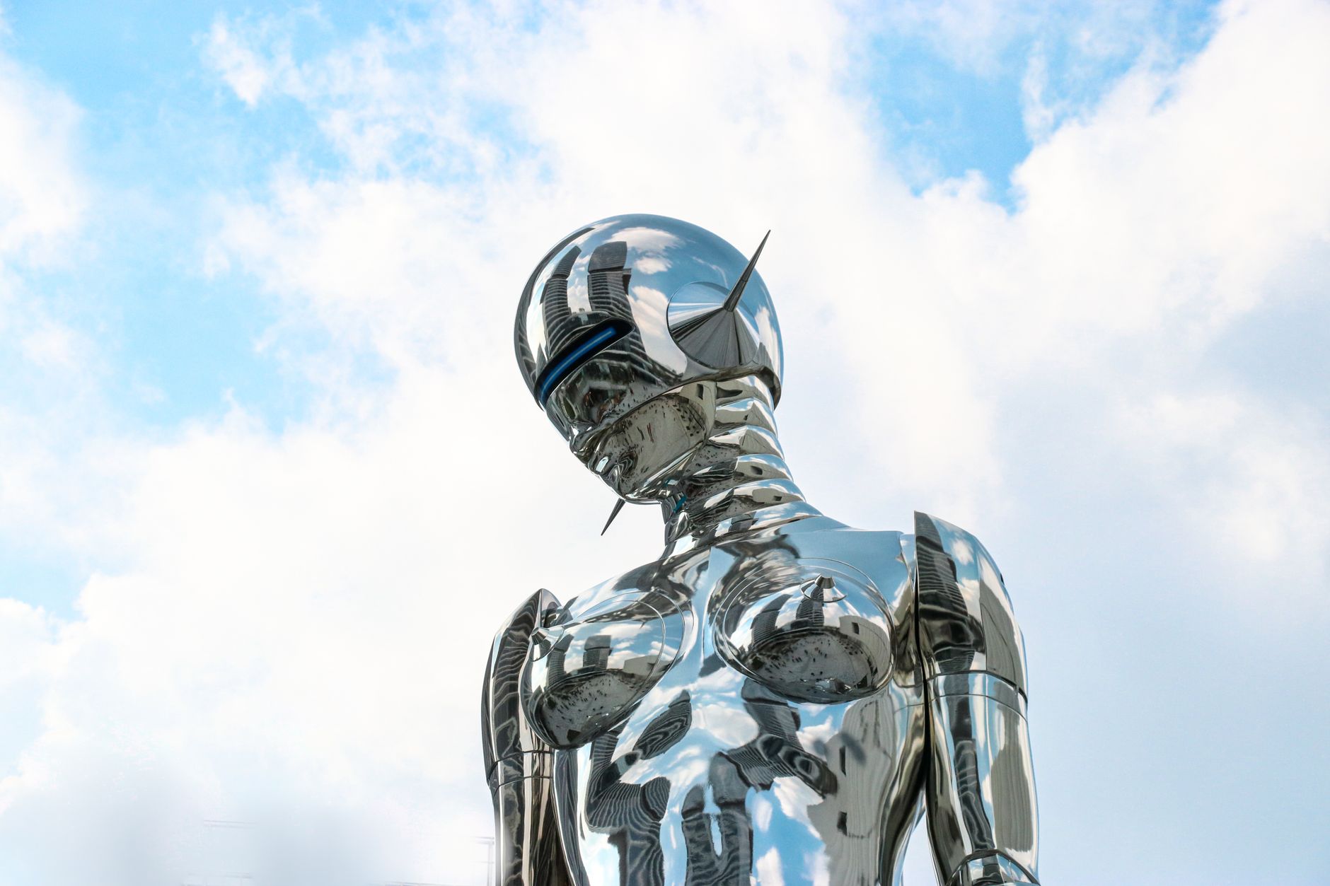 Metaliczny humanoidalny robot na tle jasnego, błękitnego nieba