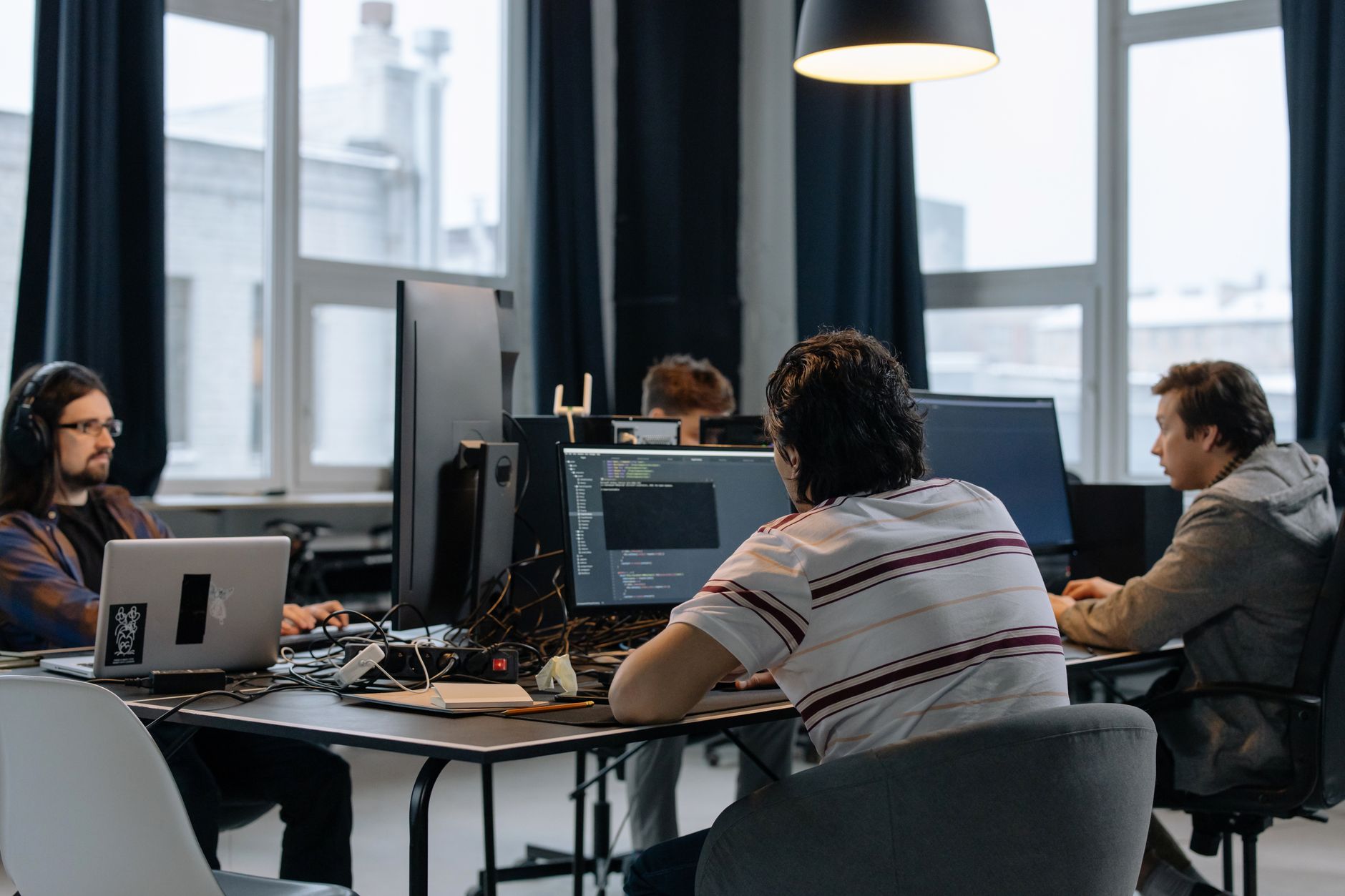 Zespół programistów pracuje wspólnie przy komputerach w nowoczesnym biurze